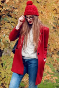 Fashion photo of  blond  woman with long hairs walking in sunny  autumn park in trendy casual outfit.
